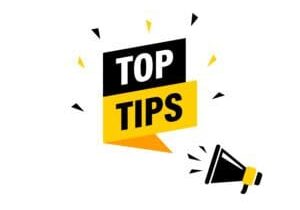 Male hand holding megaphone with Top Tips speech bubble. Loudspeaker. Banner for business, marketing and advertising. Vector illustration. Top Tips for Maximizing Your Rental Property ROI