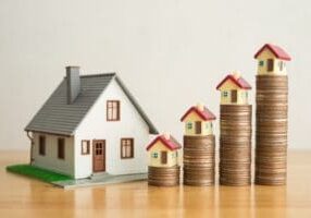 House on stack coins growth as chart on wooden table white wall background. Banking, financial, mortagage loan concept. Central bank (FED) increase interest rates effect to house price and payment. How to Set the Right Rental Price for Your Property